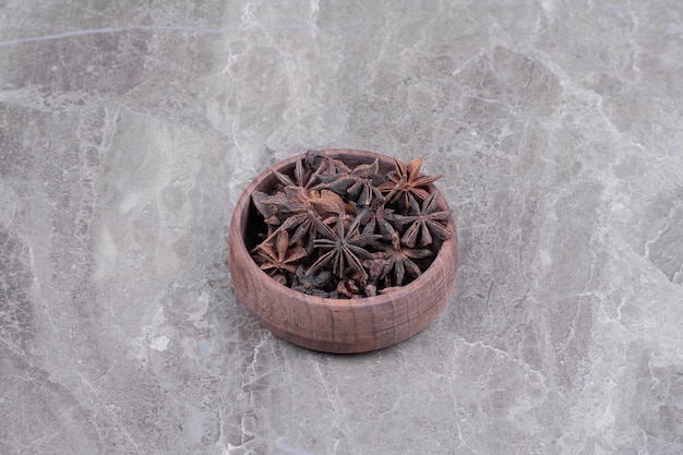 Flores de anís en una taza de madera sobre el mármol