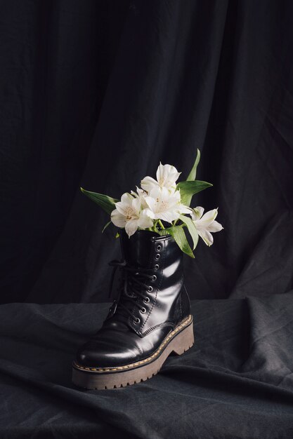 Flores blancas en bota oscura.