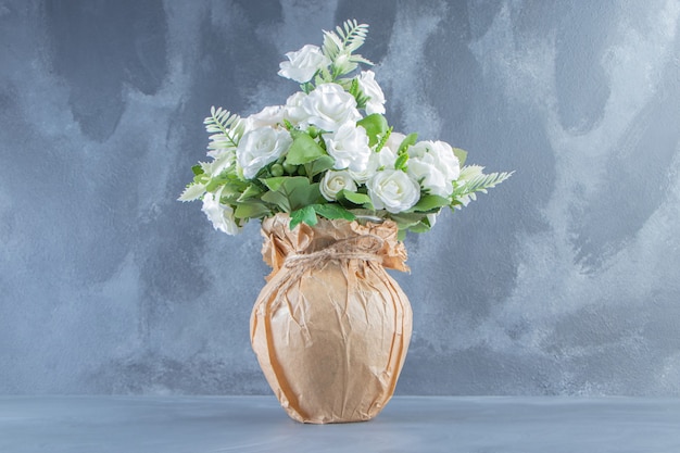 Flores blancas frescas en un jarrón, sobre el fondo de mármol.