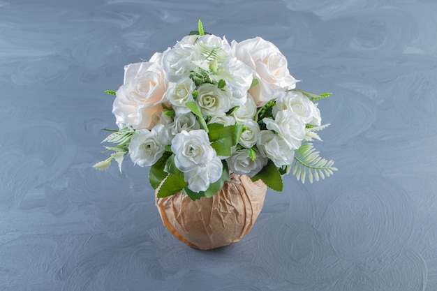 Flores blancas frescas en un jarrón, sobre el fondo de mármol.