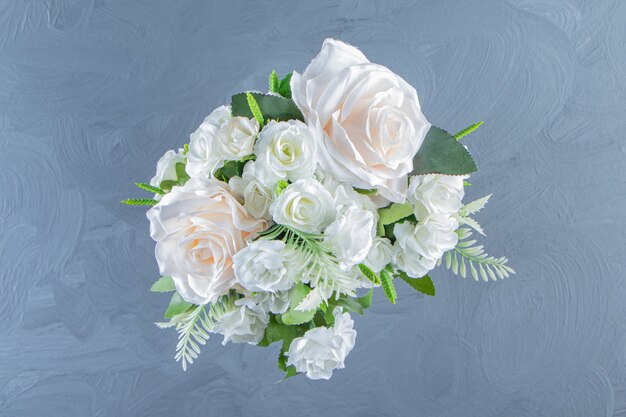 Flores blancas frescas en un jarrón, sobre la mesa de mármol.