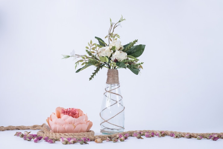 Foto gratuito flores blancas en jarrón de vidrio sobre blanco con una sola rosa.