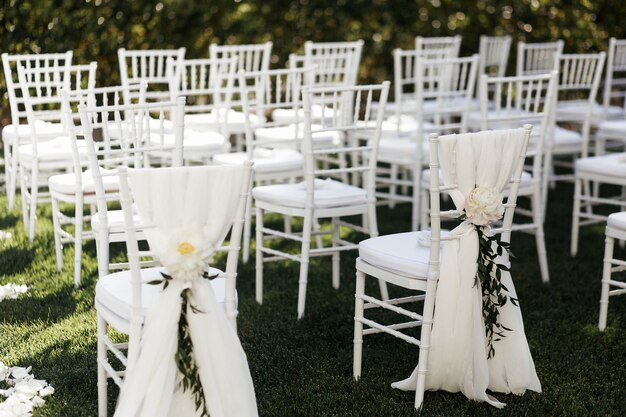 Flores blancas con ramas verdes decoran sillas