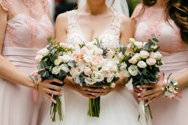 Flores de boda, novias y damas de honor que sostienen sus ramos en el día de la boda.