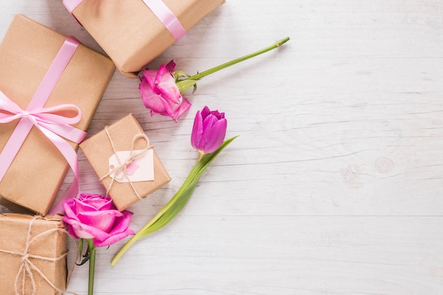 Flores con cajas de regalo en mesa.