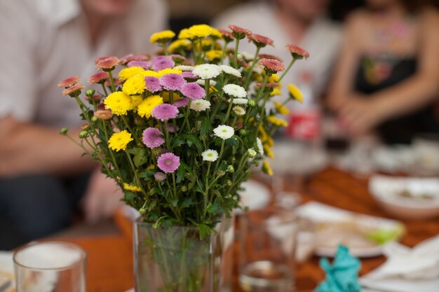 Flores de campo amarillas, violetas y blancas en un jarrón