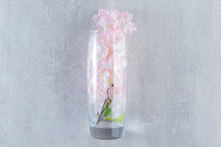 Foto gratuito flores elegantes en una jarra, sobre la mesa blanca.