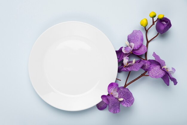 Flores florecientes con plato blanco