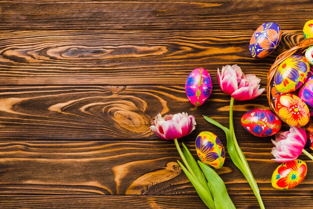 Flores frescas cerca de conjunto de huevos de Pascua