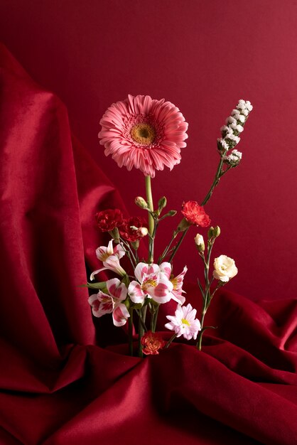 Flores en jarrón con fondo rojo.