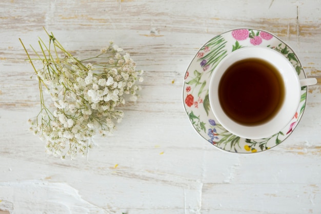 Foto gratuita flores junto a una taza de té