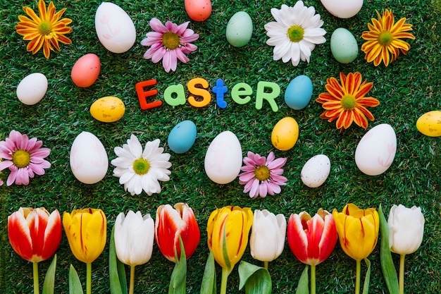 Foto gratuita flores con la palabra pascua en la hierba