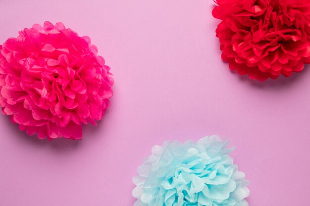 Flores de papel de colores sobre fondo rosa