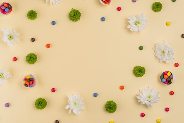 Flores con pequeños caramelos en mesa.