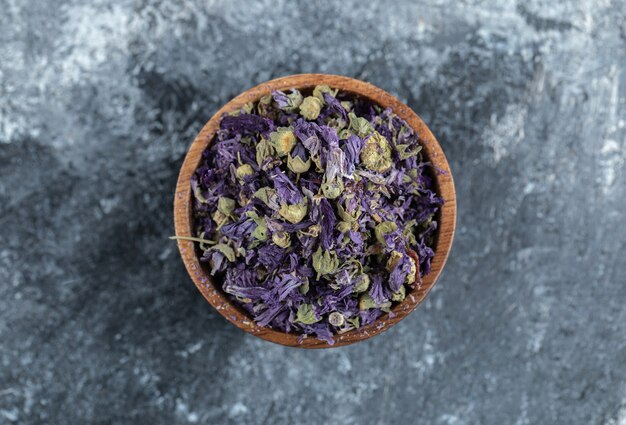 Flores púrpuras secas en un tazón de madera.