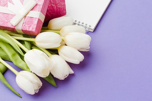 Flores de tulipán blanco y regalos envueltos en rosa