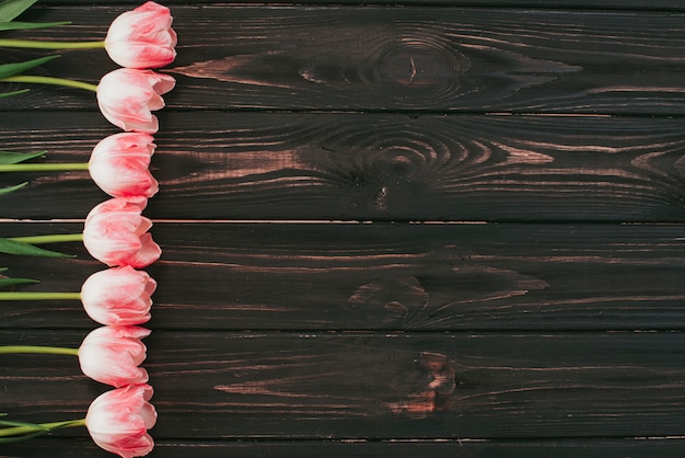 Flores de tulipán rosa en mesa de madera