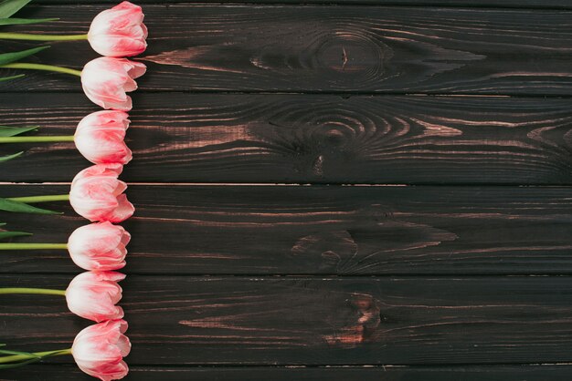 Flores de tulipán rosa en mesa de madera