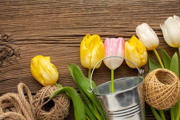 Flores de tulipanes con cubo y cuerda