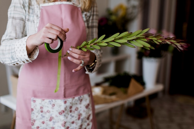 Foto gratuita florista con cinta y planta verde