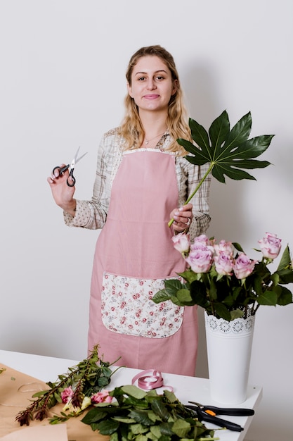 Florista con hojas verdes y tijeras