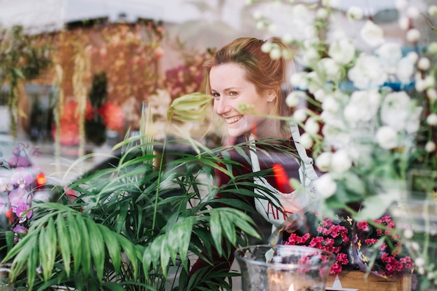 Florista mirando a través de la ventana de la tienda