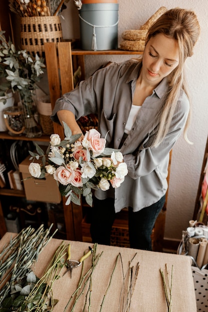 Floristería femenina haciendo un hermoso arreglo floral