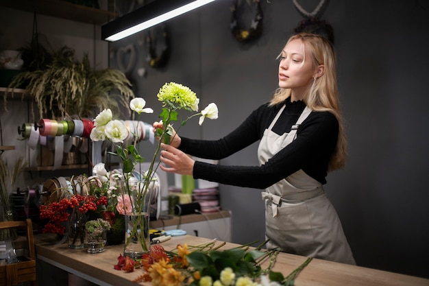 Floristería femenina haciendo un hermoso arreglo de flores