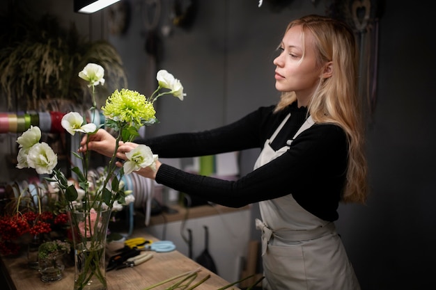 Floristería femenina haciendo un hermoso arreglo de flores