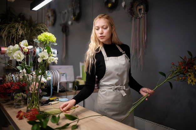 Floristería femenina haciendo un hermoso arreglo de flores