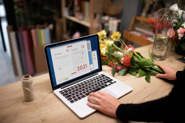 Floristería femenina usando una computadora portátil en el trabajo