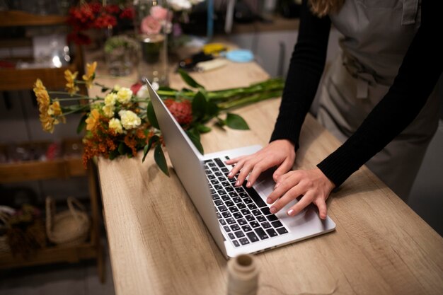 Floristería femenina usando una computadora portátil en el trabajo