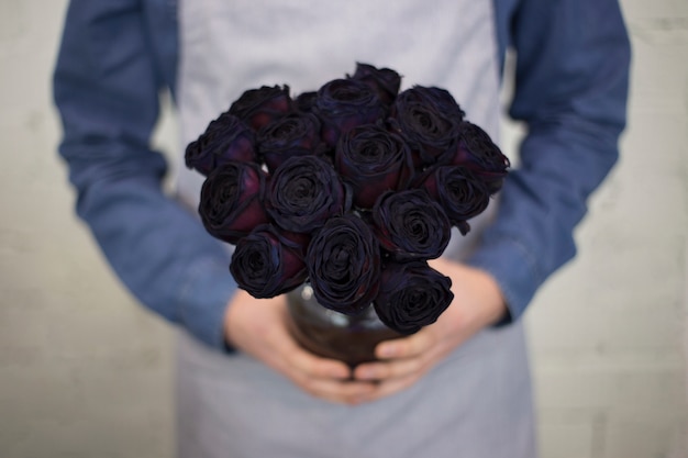 Foto gratuita floristería hombre en delantal con color brillante ramo de rosas en la mano