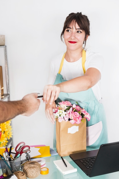 Floristería mujer tomando tarjeta de crédito del cliente