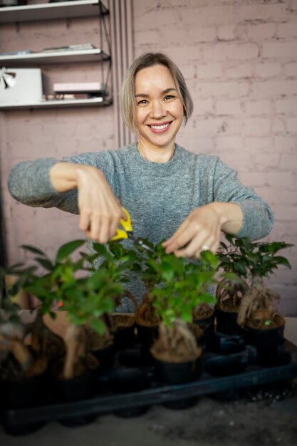 Floristería sonriente de tiro medio sosteniendo unas tijeras