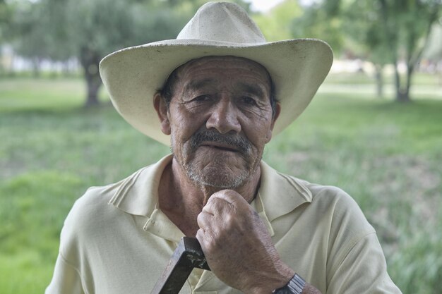 Foco superficial de un viejo agricultor hispano mirando la cámara
