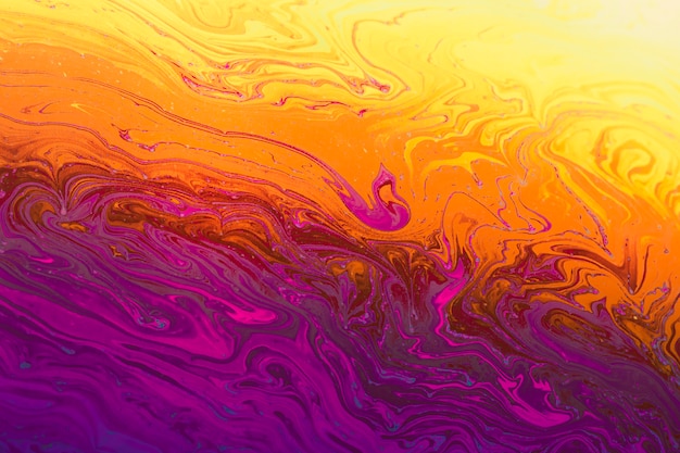 Fondo abstracto naranja y amarillo púrpura ondulado reluciente