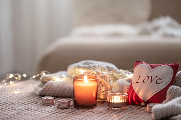 Fondo acogedor del día de san valentín con una vela y un corazón decorativo