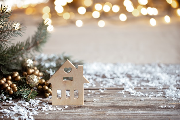 Fondo acogedor de invierno con detalles de decoración festiva, nieve en una mesa de madera y bokeh. El concepto de un ambiente festivo en casa.