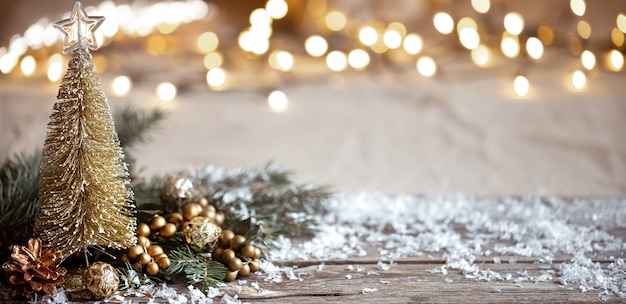 Fondo acogedor de invierno con detalles de decoración festiva, nieve en una mesa de madera y bokeh. El concepto de un ambiente festivo en casa.