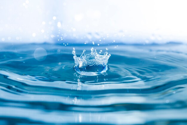 Fondo de agua con ondas y gota cayendo