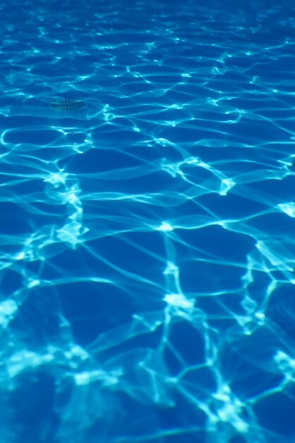 Fondo de agua ondulada azul, reflejo del sol en el agua de la piscina