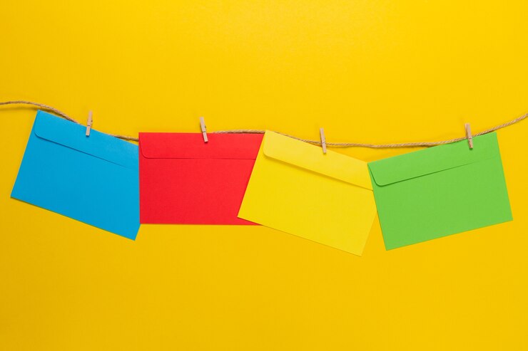 Foto gratuito fondo amarillo con sobres coloridos colgando