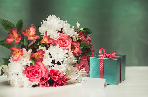 Fondo de amor con rosas rosadas, flores, regalo en la mesa