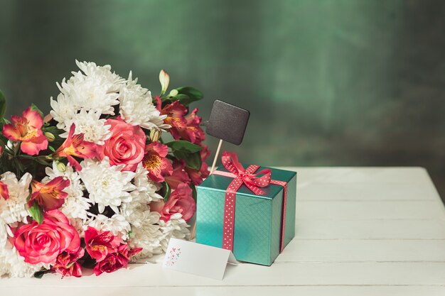 Fondo de amor con rosas rosadas, flores, regalo en la mesa
