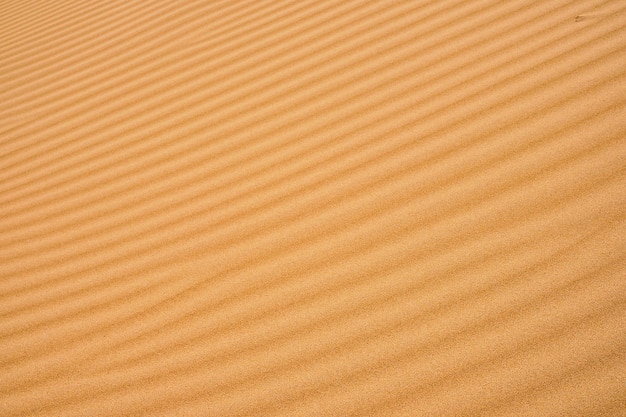 Fondo de arena ondulada para diseños o telones de fondo de verano Arena de fondo de textura de piedra arenisca natural en la playa como fondo