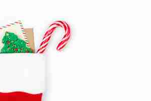 Foto gratuita fondo blanco de navidad con calcetín de papá noel con dulces de tarjeta y pan de jengibre