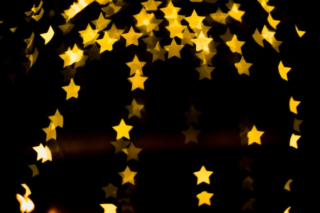 Fondo bokeh con luces amarillas en forma de estrellas