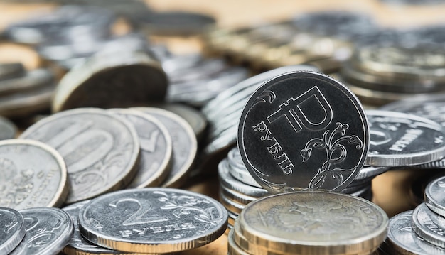 Fondo borroso fuera de foco bokeh y pasteurización Monedas del rublo ruso sobre la mesa el cambio en el tipo de cambio del rublo Idea para banner de noticias económicas