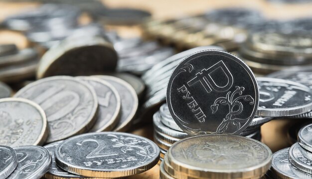 Fondo borroso fuera de foco bokeh y pasteurización Monedas del rublo ruso sobre la mesa el cambio en el tipo de cambio del rublo Idea para banner de noticias económicas
